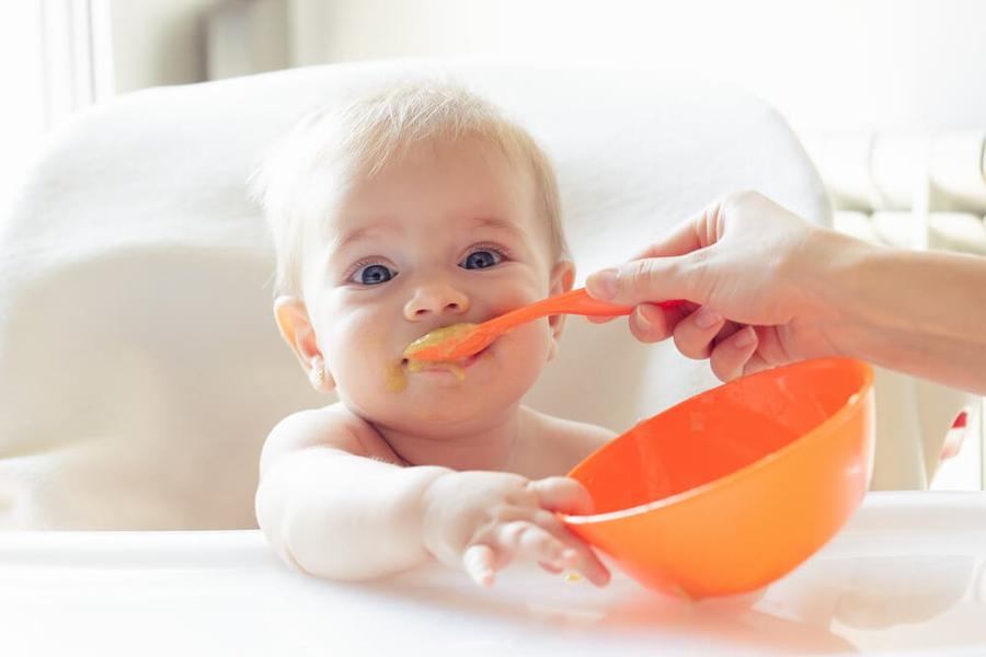 5、カラフルな食器で離乳食をもぐもぐ食べる赤ちゃん.jpg